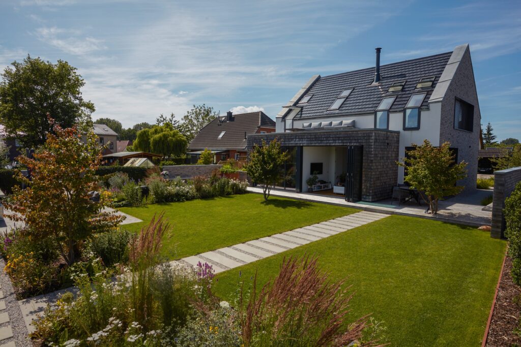 Wohnen Garten Blick auf das Haus Schrittplatten Pflanzen Parrotie Eisenholz Gärten des Jahres